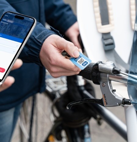 Person scanning a tag with a QR code to access Biesieklette facilities.