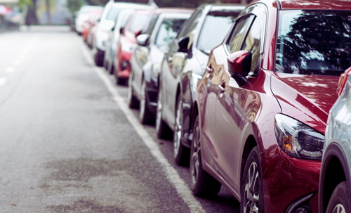 Digital permits Cars parked in a row on a street.